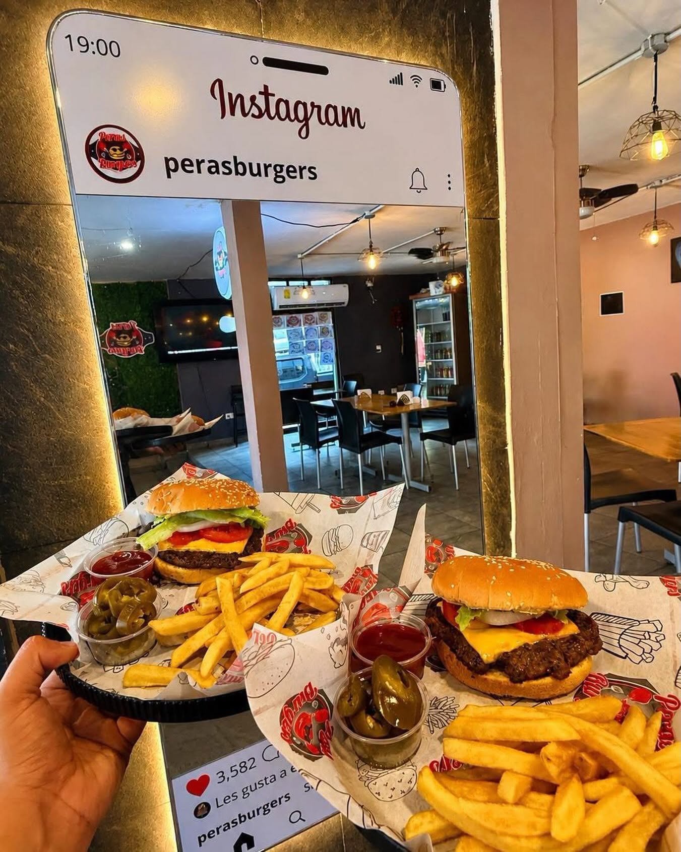 Interior del restaurante Peras Burgers con decoración moderna y platillos servidos